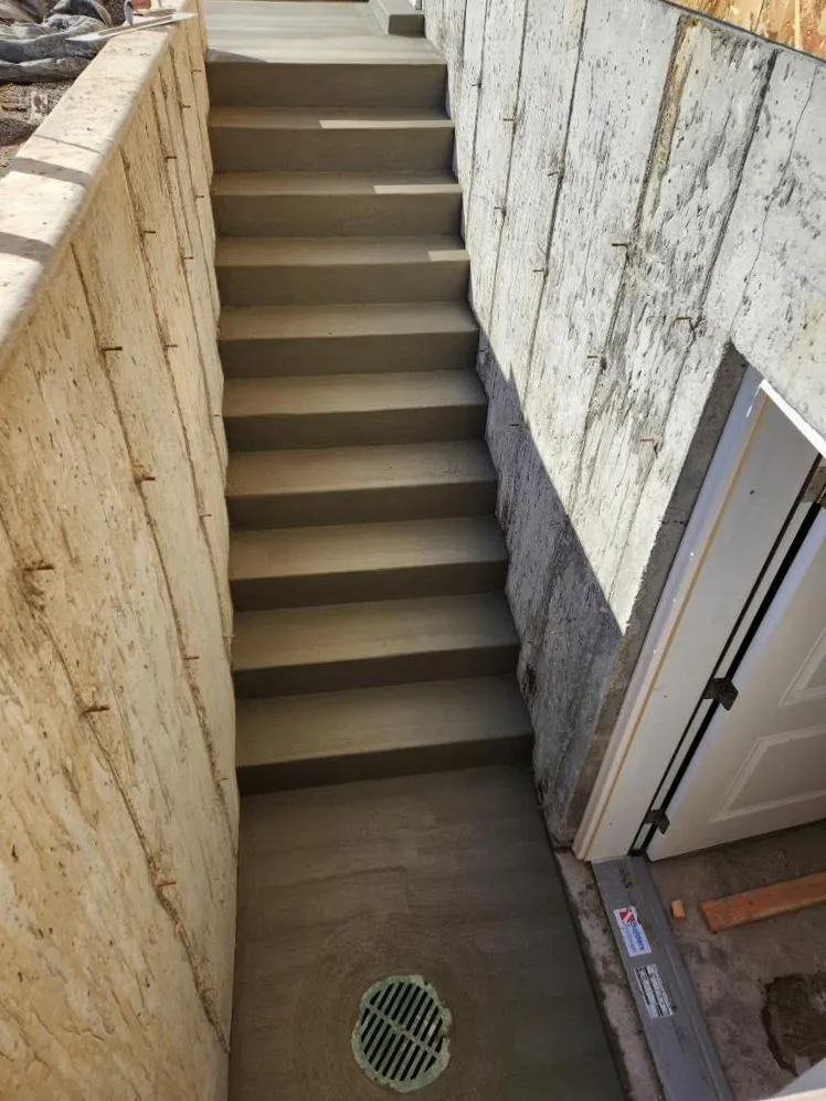 Concrete basement stairway with drain installation