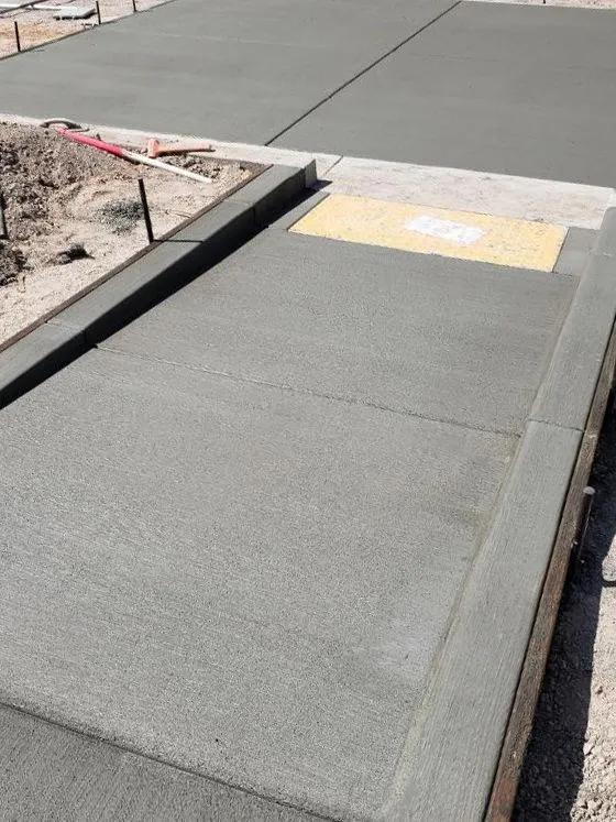 Freshly poured concrete sidewalk with accessible ramp