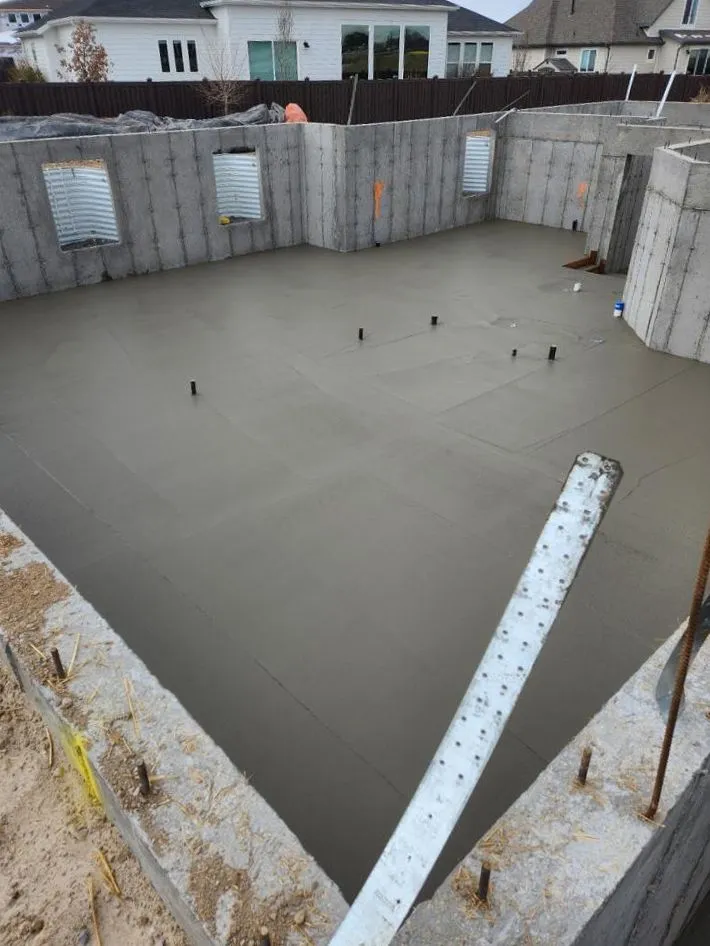 Freshly poured concrete basement floor with foundation walls