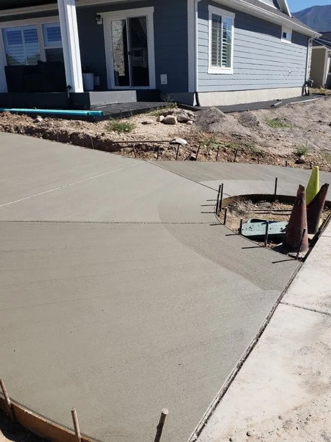Freshly poured concrete driveway in front of a residential home