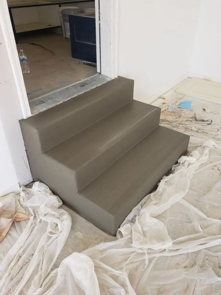 Freshly poured interior concrete steps at a doorway
