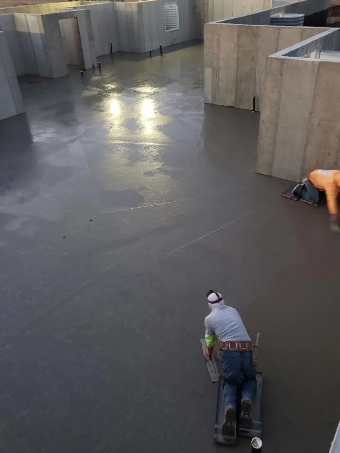 Workers smoothing a large basement concrete floor