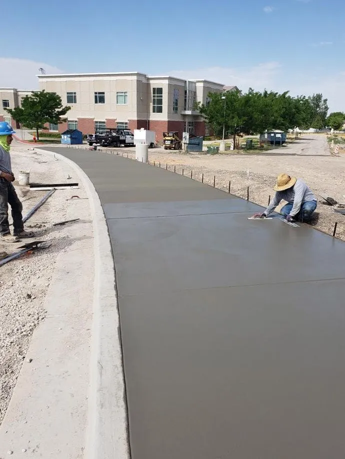 Crew finishing concrete in a large commercial warehouse