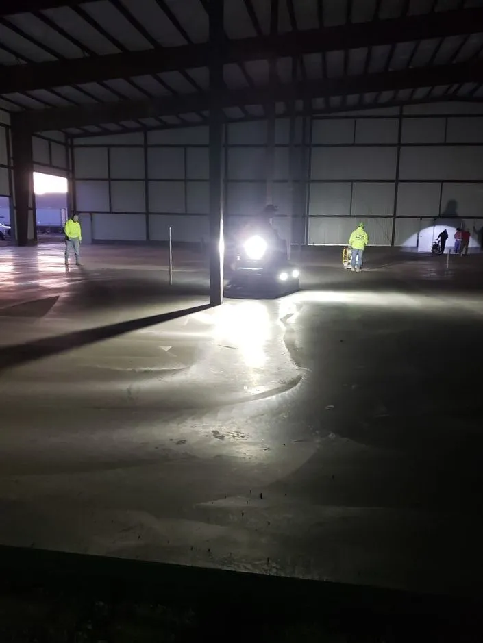Crew operating power trowels on a commercial concrete floor