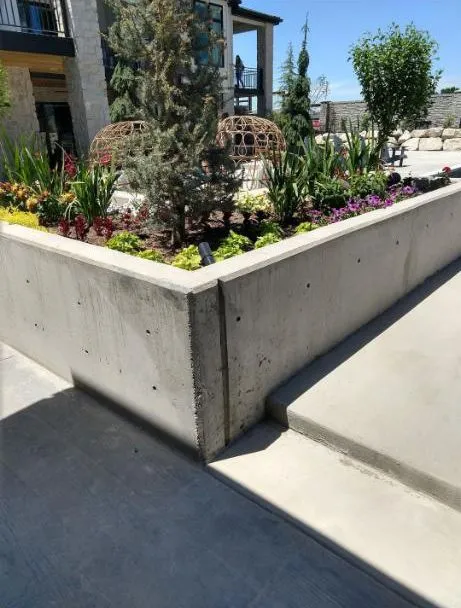Concrete planter wall with landscaping and steps at a residential property